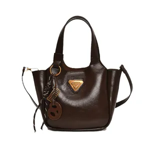 Chic dark brown faux patent leather bucket bag with top handles and shoulder strap