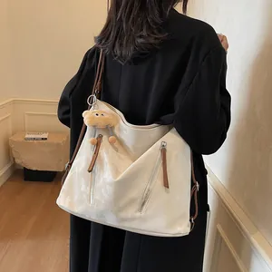Chic off-white large tote bag with brown leather straps and plush charm for daily commute