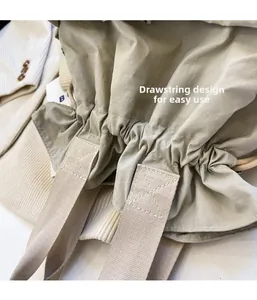 Detail of drawstring closure and wide shoulder strap on beige nylon quilted cloud bag
