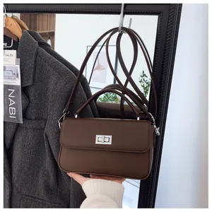 Detail of dark brown lychee leather bag with silver square twist lock and top handle