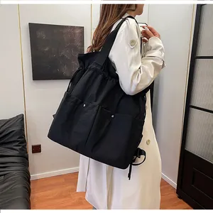 Detail of black multi-functional backpack with drawstring closure and side pockets