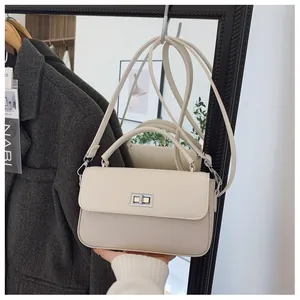 Detail of a cream faux leather square bag with silver metal twist lock and top handle
