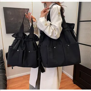 Comparison of large and small black drawstring tote bags showing interior storage and size