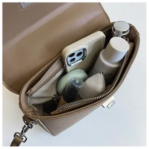 Top view of taupe pebbled leather crossbody bag interior with silver metal lock detail