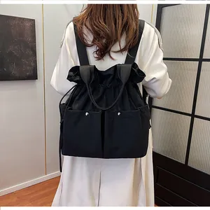 Rear view of a model wearing the black drawstring backpack with large front pockets