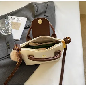 Detail view of the spacious inner compartments and zip pocket of the two-tone dumpling bag