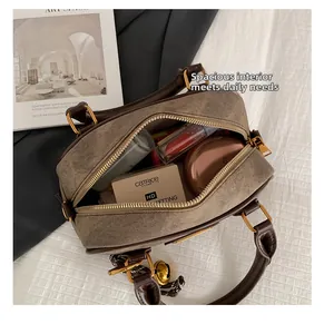 Interior view of brown textured boston bag showing capacity for cosmetics and gold zipper