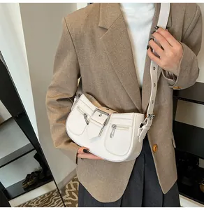 Detailansicht der weißen Lackleder-Hobo-Tasche mit Silberschnallen und Reißverschlüssen