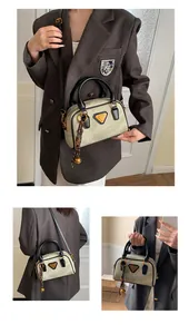 Detail view of vintage khaki bowling bag with black handles and metal triangle logo