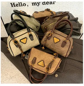 Detail view of retro matte leather bowling bags with rustic handles and gold metal plaques