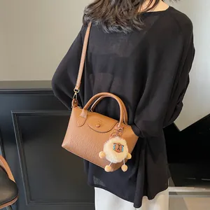 Brown faux leather crossbody bag with twin handles and cute white alpaca charm