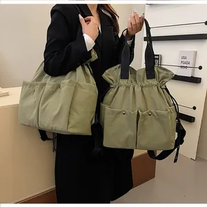 Detail view of army green multi-pocket tote bag with drawstring closure and metal buckles