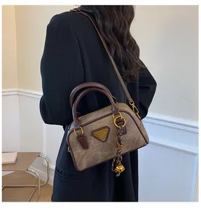 Detailed back view of vintage brown bowling handbag worn with adjustable strap