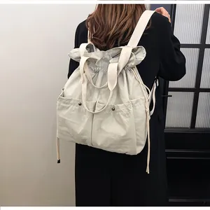 Detailed back view of a grey drawstring nylon backpack with dual front pockets