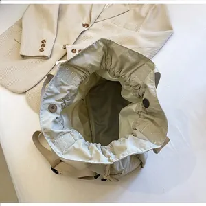 Top view of beige drawstring bucket bag interior with zipper pocket and magnetic closure