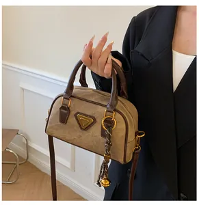 Detail of vintage bowling bag with canvas body, brown leather trim and golden bell charm
