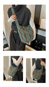 Detalle del patrón zigzag azul y verde en bolso de punto afelpado con correa ancha
