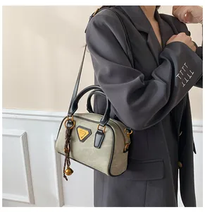 Detail showing vintage mini Boston bag with suede texture and metal logo worn by a model