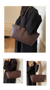 Detail view of large brown leather tote bag with fine stitching and shoulder straps