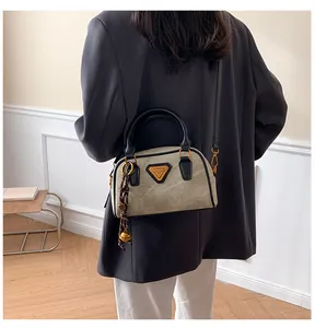 Detailed back view of a taupe Boston bag with black handles on a model in home setting