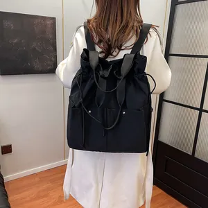 Versatile black drawstring backpack and tote bag with multi-pocket design on model