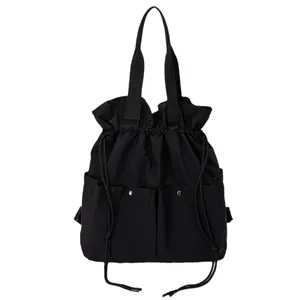 Lightweight black drawstring tote bag with dual front pockets and large capacity