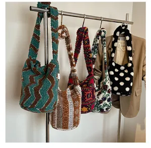 Primer plano de bolsos tipo cubo de pelo sintético con varios estampados en un soporte