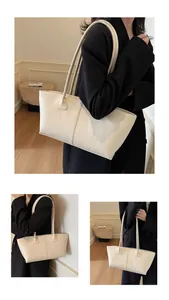 Detail of cream minimalist tote bag with vertical stitching and slim shoulder straps