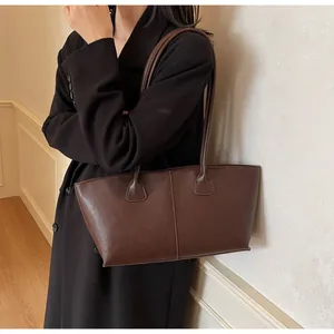 Detail of dark brown leather tote bag with vertical stitching for commuter style
