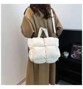 Detailed back view of a white quilted puffer bag with a puffy handle and shoulder strap