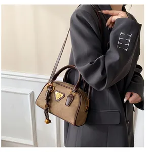 Detail of a two-tone khaki Boston bag with suede texture and metal triangle logo