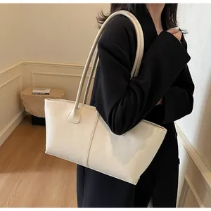 Detail view of cream white matte leather tote bag with elegant vertical stitching and slim straps