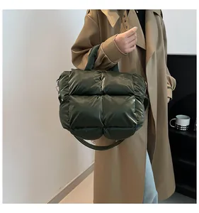 Detail of dark green quilted padded tote with metallic D-ring and adjustable strap