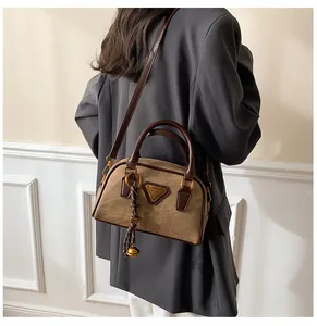 Detail view of retro Boston bag in khaki brown with metallic logo and bell charm