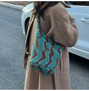 Detalle del bolso tote de piel sintética con ondas azules y marrones en una modelo