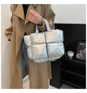 Chic silver quilted tote bag with wide shoulder straps shown in a street style setting