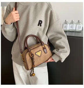 Retro Boston bag in brown suede and leather crossbody style shown on a model