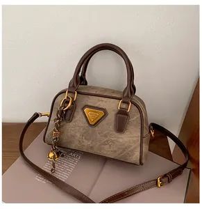 Detail of vintage brown bowling bag featuring marble texture and gold triangular logo