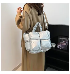 Silver metallic quilted space tote bag styled with a trench coat for daily commute