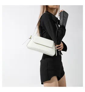 Detail view of the white baguette bag with matte leather finish and gold hardware accents