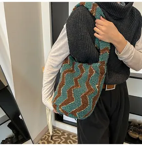 Detalle del bolso de hombro de punto ondulado verde y marrón con textura de lana suave