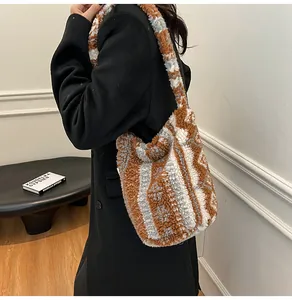 Detalle del bolso tote de felpa a rayas con textura de borrego y correa ancha al hombro