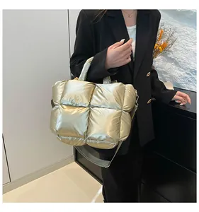 Detail of champagne gold quilted puffer bag with crossbody strap and padded handle