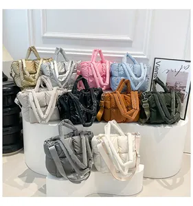 Multiple colors of quilted padded tote bags displayed on a modern minimalist curved stand