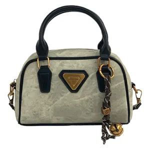 Vintage grey denim bowling bag with black leather trim and golden bell pendant charm