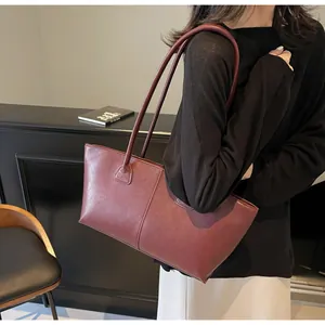 Detailed view of large burgundy PU leather tote bag with vertical stitching and slim straps