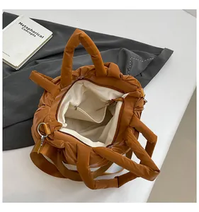 Top view of brown quilted handbag showing the spacious interior and zipper pocket