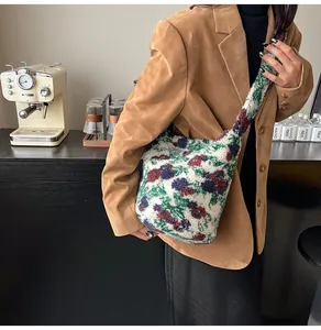 Detalle de textura de bolso tote floral de felpa con tejido suave y estampado vivo