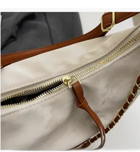 Macro shot of smooth golden zipper and brown leather puller on the off-white tote bag