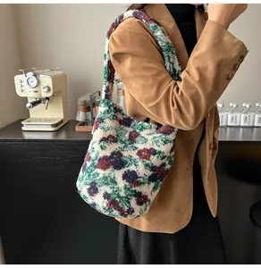 Detalle de bolso bucket de punto floral con textura de felpa y chaqueta de pana